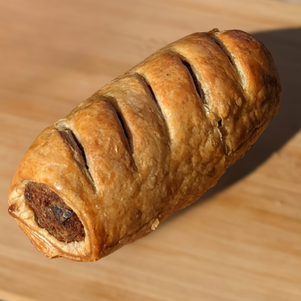 Baked sausage roll on a wooden surface